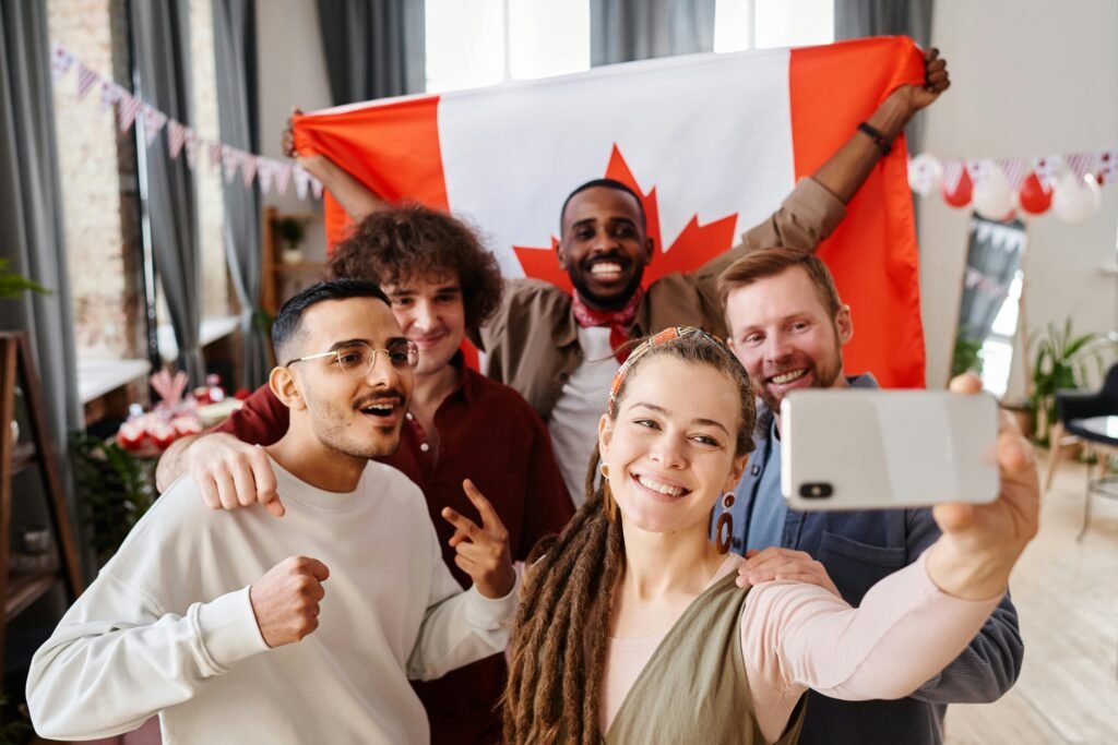 A diverse group of friends celebrating Canada Day with a joyful selfie indoors.